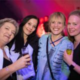Vier Frauen stehen teilweise mit Drinks in der Hand auf der Tanzfläche im Kühlschiff in Unna und lächeln in die Kamera