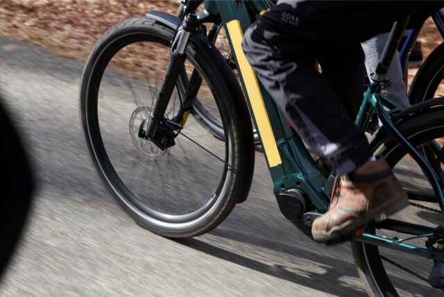 Ein E-Bike rollt zügig über einen asphaltierten Weg.