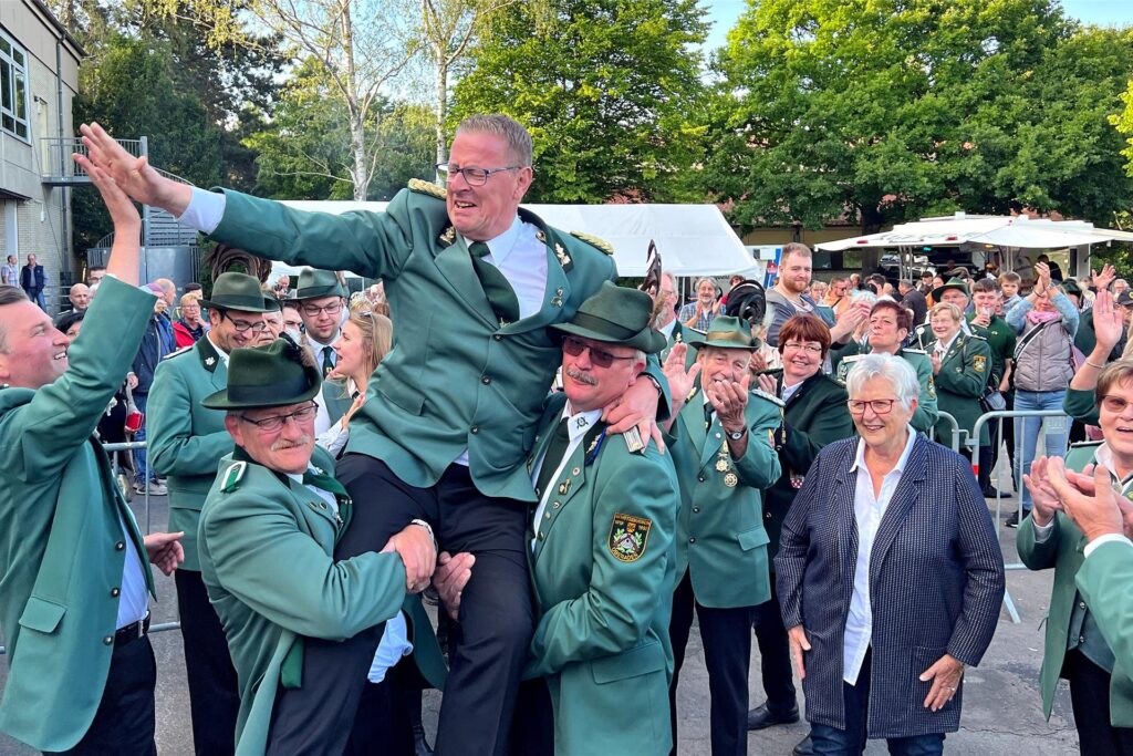 Ralf Klute wir von anderen Schützen beim Schützenfest in Oberaden 2022 hochgehoben (A.)