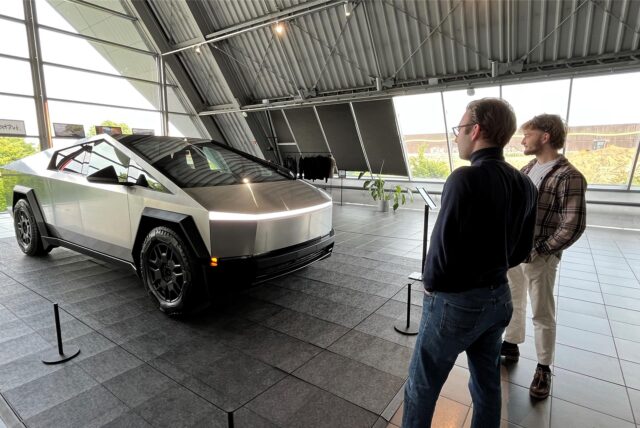 Zwei Besucher schauen sich den futuristisch wirkenden Cybertruck an. Der Elektro-Pickup steht vier Tage lang im Teslacenter Dortmund Holzwickede.