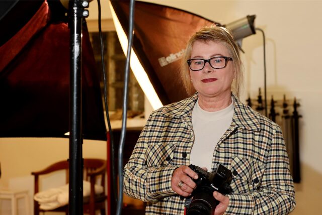 Marie Reh vom Fotostudio Reh steht mit einer Kamera im Studio.