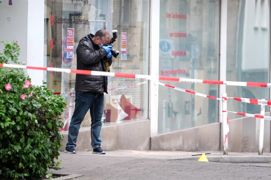 Eine Einsatzkraft fotografiert den Tatort. Nach Schüssen in der Essener Innenstadt fahndet die Polizei mit einem Großaufgebot nach den geflohenen Tätern. Eine Einsatzkraft fotografiert den Tatort. Nach Schüssen in der Essener Innenstadt fahndet die Polizei mit einem Großaufgebot nach den geflohenen Tätern.