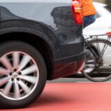 Ein Fahrradfahrer fährt zwischen zwei fahrenden Autos her.