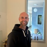 Lukas Heine vor dem Fenster zum Flur an der Kochnische seiner neuen Wohnung in der früheren Abendrealschule.