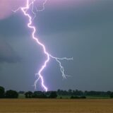 Ein Blitz schlägt in ein Feld ein.