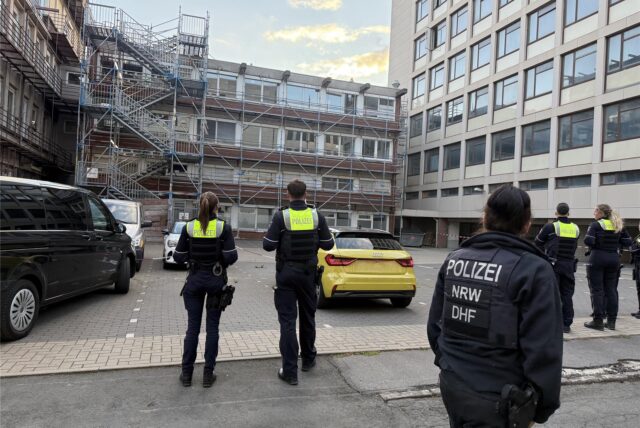 Polizisten stehen vor dem früheren Max-Planck-Institutsgebäude an der B1.