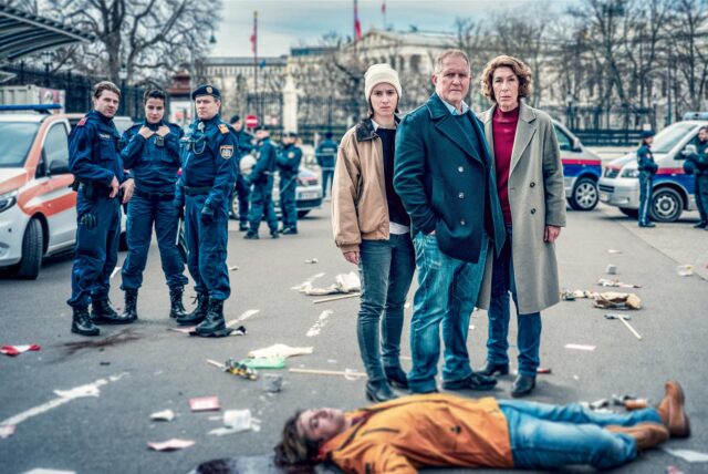 Meret Schande (Christina Scherrer), Moritz Eisner (Harald Krassnitzer) und Bibi Fellner (Adele Neuhauser), die Ermittler im Tatort Wien, stehen hinter der Leiche des Demonstranten Jakob Volkmann (Tilman Tuppy).