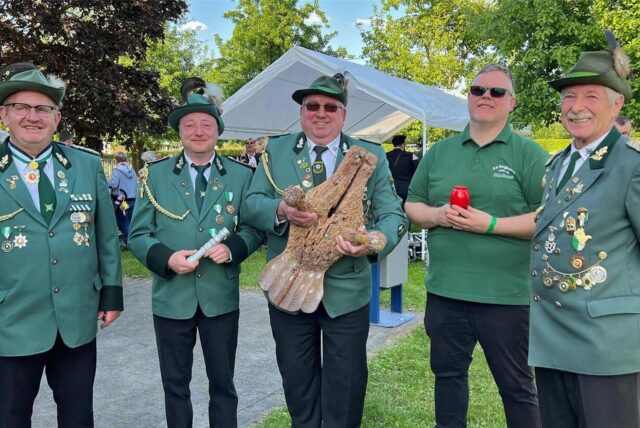 Fünf Männer des Schützenvereins Bergkamen 1840 stehen vor der Kamera. Werner Spitzenberger (Mitte) hält den Holzvogel in der Hand, den er 2023 herunterschoss. Er teilte sich den Erfolg mit (v.l.) Marcus Prill, Nico Block, Michael Kitzig und Franz Schulz.