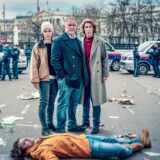 Meret Schande (Christina Scherrer), Moritz Eisner (Harald Krassnitzer) und Bibi Fellner (Adele Neuhauser), die Ermittler im Tatort Wien, stehen hinter der Leiche des Demonstranten Jakob Volkmann (Tilman Tuppy).
