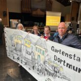 Vier Vertreter der Bürgerinitiative „Freunde der Gartenstadt“ halten ein Transparent, mit dem auf die Verkehrsprobleme in der Gartenstadt aufmerksam gemacht wird.