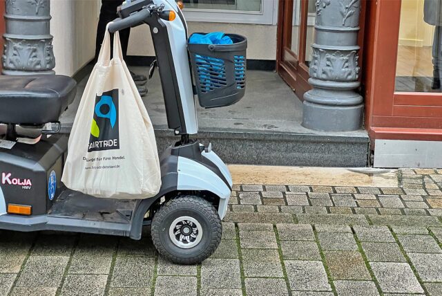Ein elektrischer Rollstuhl steht vor einer Stufe in Kamen.