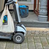 Ein elektrischer Rollstuhl steht vor einer Stufe in Kamen.