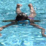 Ein Mädchen taucht durch das Wasser des Freibad Bornekamp.
