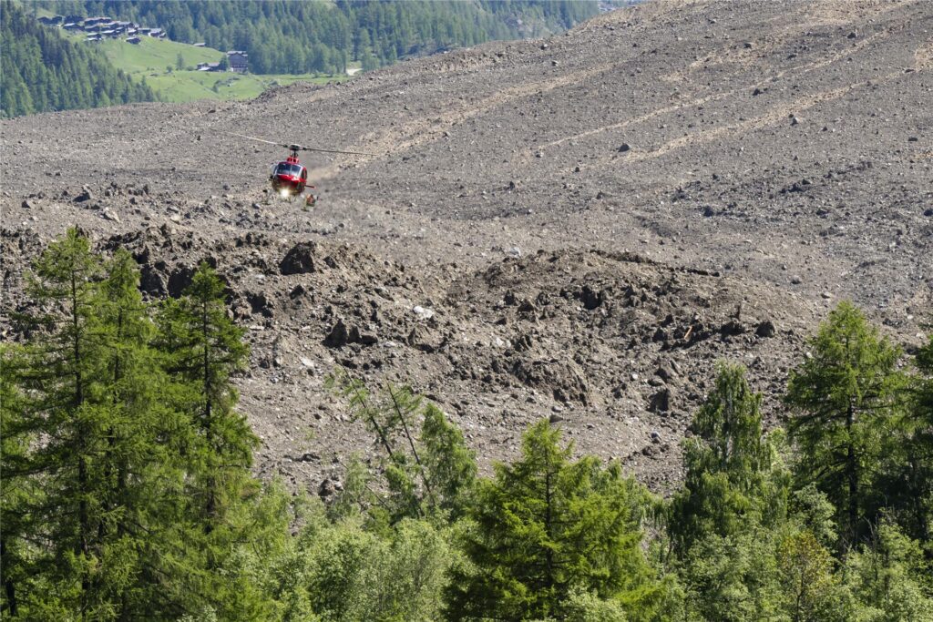 Ein Helikopter der Air Zermatt fliegt einen Tag nach der massiven Lawine, die durch den Abbruch des Birchgletschers ausgelöst wurde, über die Geröllhalde. Ein großer Teil des Dorfes Blatten im Lötschental im Kanton Wallis wurde unter Massen von Eis, Schlamm und Felsen begraben. Ein Helikopter der Air Zermatt fliegt einen Tag nach der massiven Lawine, die durch den Abbruch des Birchgletschers ausgelöst wurde, über die Geröllhalde. Ein großer Teil des Dorfes Blatten im Lötschental im Kanton Wallis wurde unter Massen von Eis, Schlamm und Felsen begraben.