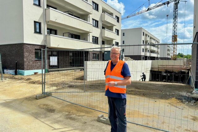 Beta-Bauleiter Gerd Scherf vor der Tiefgaragen-Einfahrt mit den Neubauten.