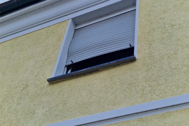 Eine Fensterrollo ist nach dem Brand eines Autos verzogen.