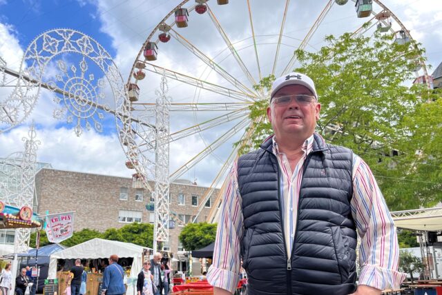 Achim Megger, Bürgermeisterkandidat in Unna 2025, posiert unweit des Rathauses vor einem Riesenrad und der Deko der Festa Italiana