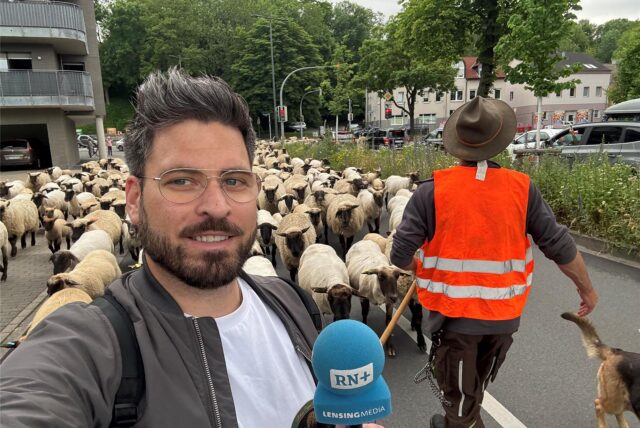 Ruhr Nachrichten-Reporter Stefan Schier steht vor der Schafherde, die durch Dortmund zieht.