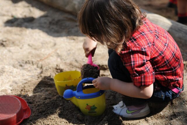 Kind spielt im Sand