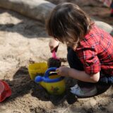 Kind spielt im Sand