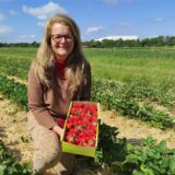 Claudia Döring hält einen Korb Erdbeeren ins Bild.