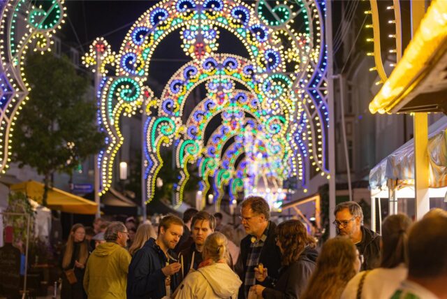 Menschen flanieren bei Einbruch der Dunkelheit über das Gelände der Festa Italiana in Unna.