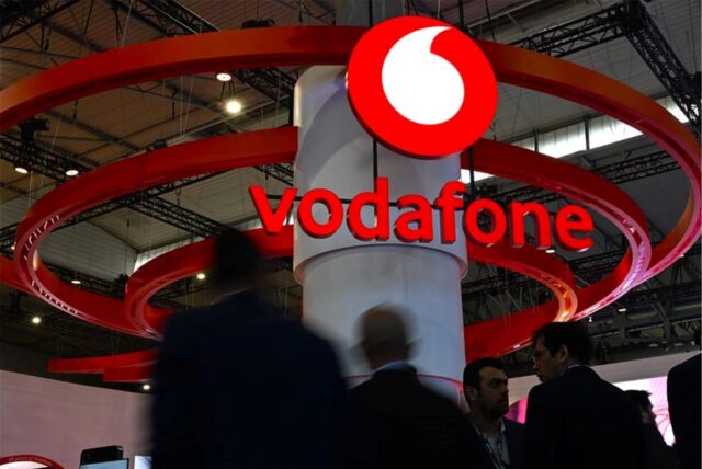 Besucherinnen und Besucher der Mobilfunk-Messe Mobile World Congress (MWC) gehen am Messestand des Telekommunikationskonzerns Vodafone vorbei. 