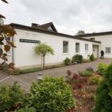 Links Körbe mit Lebensmitteln, darunter Toast und Bananen, rechts das Martin-Luther-Haus in Bergkamen
