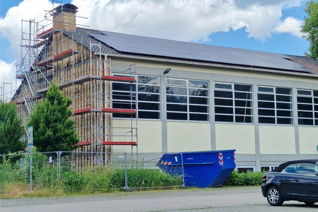 Die Turnhalle der Massener Sonnenschule ist eingerüstet: Seit Montag nehmen Arbeiter die asbesthaltigen Faserbetonplatten der Fassade ab.