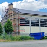 Die Turnhalle der Massener Sonnenschule ist eingerüstet: Seit Montag nehmen Arbeiter die asbesthaltigen Faserbetonplatten der Fassade ab.