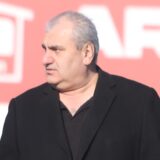 Imdat Acar steht mit Spielern vom Lüner SV auf dem Sportplatz.