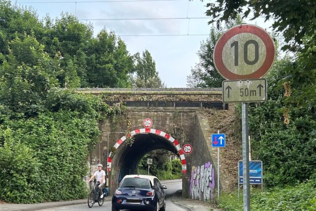 Ein Auto und ein Radfahrer fahren durch einen Tunnel.