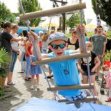 Ein Junge in blauem Shirt und mit blauer Kappe klettert beim Hafenfest in der Marina Rünthe in Bergkamen eine Strickleiter hinauf.