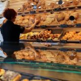 Eine Mitarbeiterin räumt Brot in die Auslage einer Bäckerei.