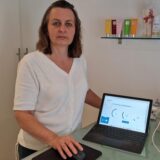 Anja Weiskamp steht an der Rezeption ihrer Fußpflegepraxis in Dortmund-Holthausen. Neben sich ist ein Tablet, dass die Internetverbindung testet.