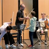 Familiensache: Der Sohn von Giovanni Guzzo (stehend) und Mirijam Contzen assistiert auf der Bühne im Theater des Schlosses Cappenberg. Klar, dass auch er selbst schon Geiger ist.