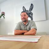 Sven Arnt vom lokalen Wählerbündnis „Wir für Unna“ sitzt mit verschränkten Armen an einem Holztisch