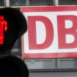 Eine Fußgängerampel, vor dem Logo der Deutschen Bahn (DB) am Münchner Hauptbahnhof, leuchtet Rot.