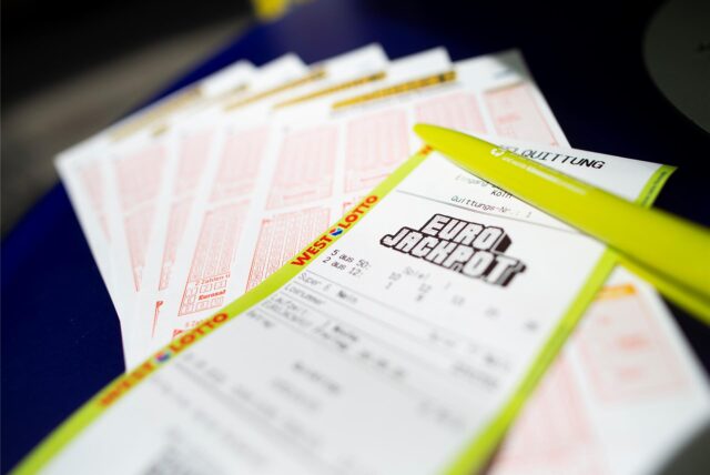 Tippscheine und eine Spielquittung für den Eurojackpot liegen in einer Lotto-Annahmestelle auf einem Tisch.