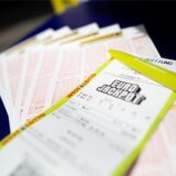 Tippscheine und eine Spielquittung für den Eurojackpot liegen in einer Lotto-Annahmestelle auf einem Tisch.