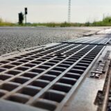 Die Wasserablaufrinne neben dem Bahnübergang an der Twiete lässt Autos aufschaukeln wie die folgenden Gleise.