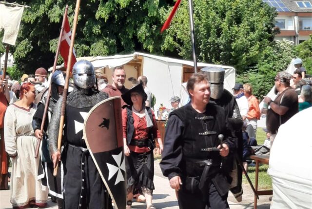 Schausteller in Mittelaltertracht und Rüstung.