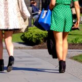 Zwei Frauen gehen in kurzer Hose und kurzem Rock einen Weg entlang.