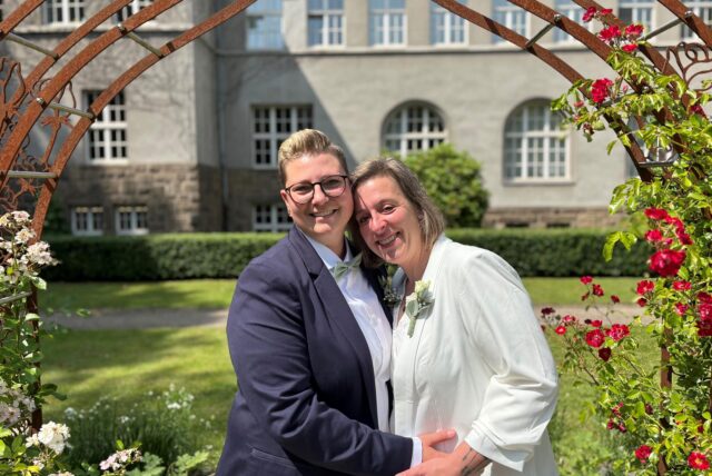 Alexandra (36) und Janine (38) stehen vor dem Schwerter Rathaus unter dem Rosenbogen. Das Paar hat im Standesamt geheiratet.