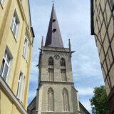 Der Turm der Evangelischen Stadtkirche in Unna fotografiert durch die schmale Gasse zwischen Kirchplatz und Bahnhofstraße-