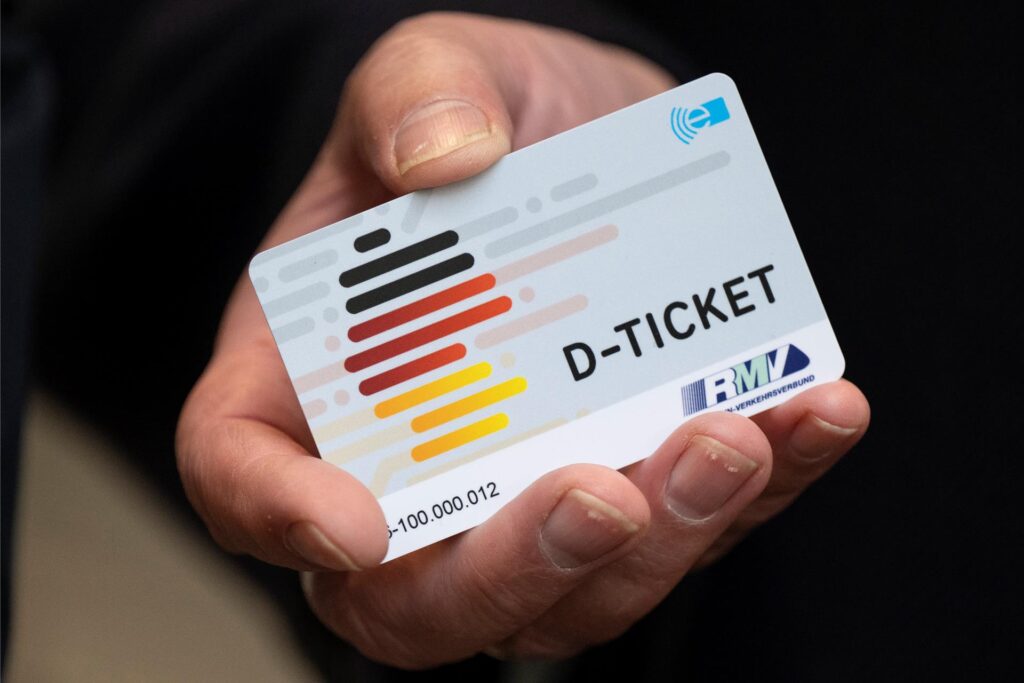 Jemand hält ein Deutschlandticket in der Hand. Jemand hält ein Deutschlandticket in der Hand.