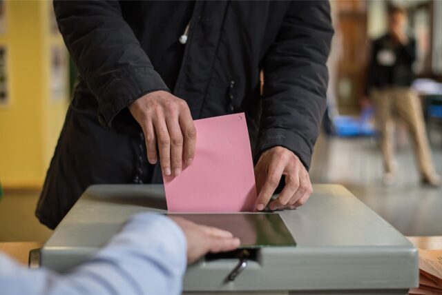 Ein Mann wirft seinen Stimmzettel in die Wahlurne