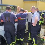 Ein Feuerwehrmann versucht durch einen Spalt den Schlüssel vom Beifahrersitz zu angeln.