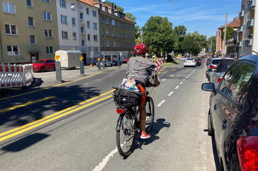 Eine Radfahrerin fährt durch eine enge Baustellenführung. Eine Radfahrerin fährt durch eine enge Baustellenführung.