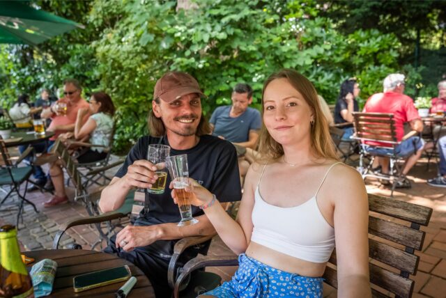 Ein Mann und eine Frau stoßen im Biergarten Hopfen und Salz in Dortmund an.